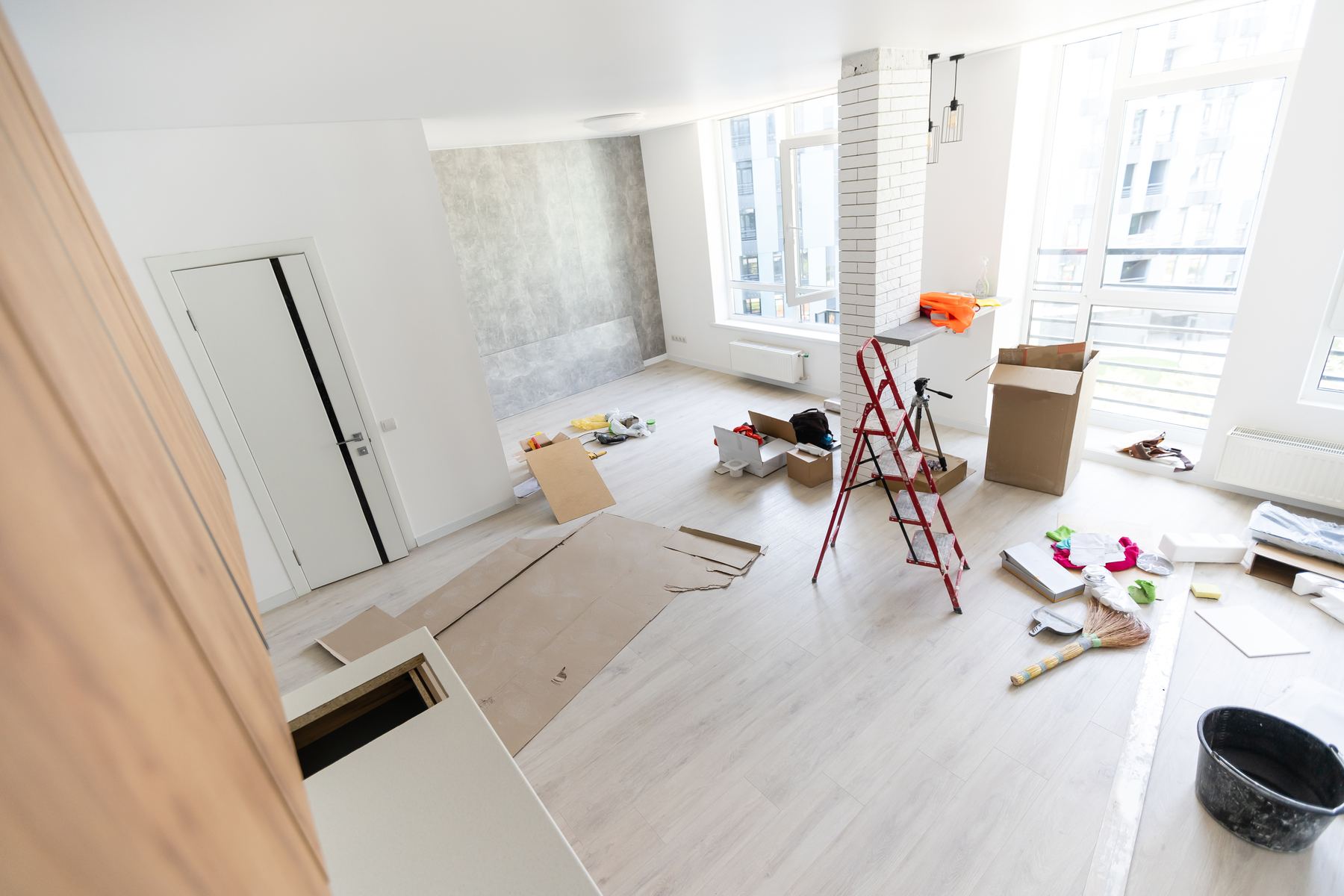 Light laminate flooring being installed in a bright condo
